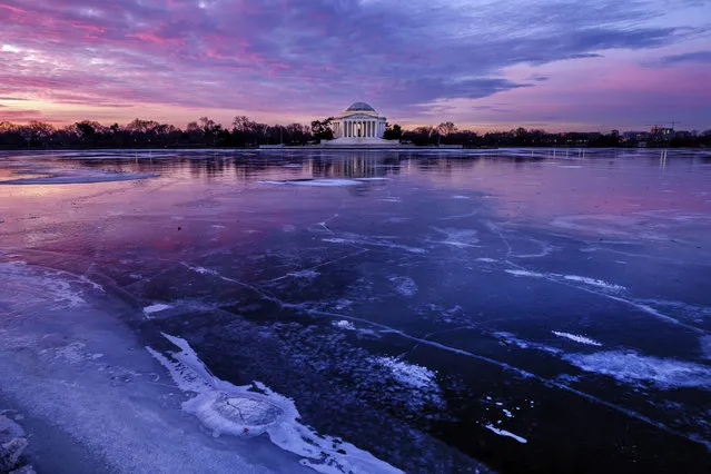 The Jefferson Memorial is reflected in the frozen surface of the Tidal Basin at daybreak in Washington, Monday, January 8, 2018. The Tidal Basin, famous for the Cherry Trees that surround it, is a sheet of ice after several days of bitter cold weather in the Nation's Capital. (Photo by J. David Ake/AP Photo)