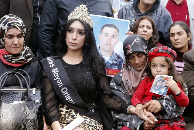 The mother and child (R) of Lebanese soldier Ali al-Bazzal, who was killed by Syria's al Qaeda offshoot Nusra Front, sit beside Miss Middle East (C) and other protesters as they demand the release of remaining soldiers, pressuring the government to act, in downtown Beirut December 14, 2014. (Photo by Mohammed Azakir/Reuters)