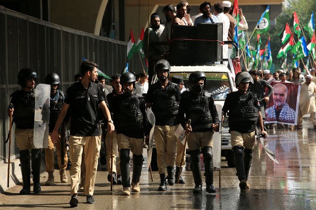 Pakistani security officials stand guard as Supporters of the Islamic political party Jamaat-e-Islami (JI) protest in a march towards the US Consulate in support of the Palestinian people and against Israel's interception of the Global Sumud Flotilla (GSF) vessels, in Peshawar, Pakistan, 03 October 2025. The Global Sumud Flotilla, an international maritime initiative with representatives from over 40 countries that began sailing in August 2025 to the Gaza Strip, aims to break the Israeli blockade and deliver humanitarian aid to Gaza. (Photo by Arshad Arbab/EPA)