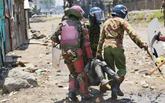 Riot police officers detain a supporter of Kenya's opposition leader Raila Odinga of the Azimio La Umoja (Declaration of Unity) One Kenya Alliance, as they participate in a nationwide protest over cost of living and President William Ruto's government in Mathare settlement in Nairobi, Kenya on March 27, 2023. (Photo by John Muchucha/Reuters)