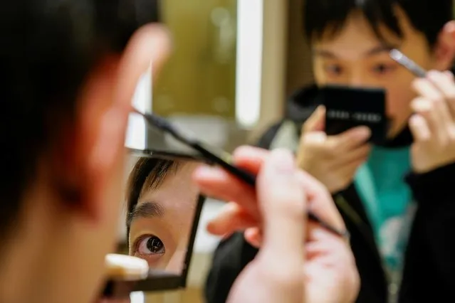 Liu Yuxuan, 22, a student, puts on his make-up at a restroom in a shopping mall in Shanghai, China, December 3, 2020. (Photo by Aly Song/Reuters)