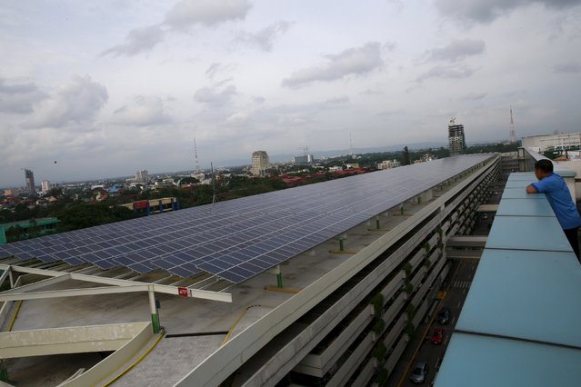A worker looks at solar panels on the roof deck of a mall in Quezon city, metro Manila July 13, 2015. Solar companies will push the Philippine government to quadruple the size of an incentive scheme for suppliers of the renewable energy and to speed up project approvals, as the country grapples with precarious electricity supply. (Photo by Romeo Ranoco/Reuters)