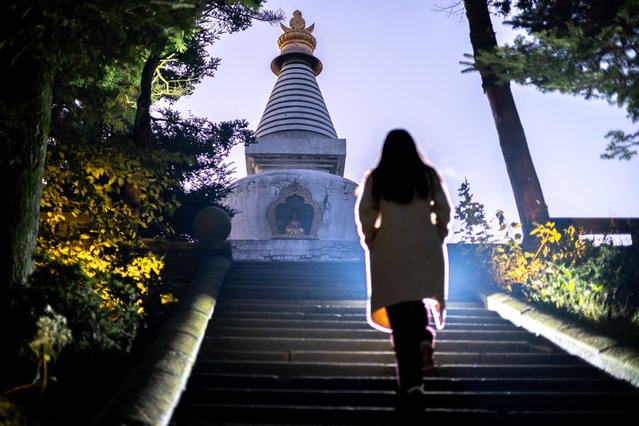 A woman walks up stairs to a stuppa on LuShan mountain in Jiangxi, China on Wednesday, October 22, 2025. (Photoby Dan Sandoval/AP Content Services for Lushan Tourism)