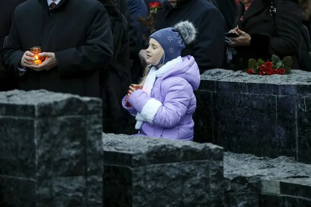 A girl holding a candle attends a commemoration ceremony at a monument for Holodomor victims marking the 82nd anniversary of the famine of 1932-33 in which millions died of hunger in Kiev, Ukraine, November 28, 2015. (Photo by Gleb Garanich/Reuters)