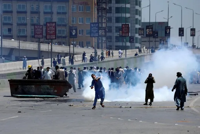Supporters of Pakistan's former Prime Minister Imran Khan throw stones towards police during a protest against Khan's arrest, in Peshawar, Pakistan on May 10, 2023. (Photo by Fayaz Aziz/Reuters)