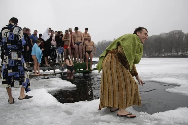 People gather to immerse themselves in icy waters during celebrations for Orthodox Epiphany in Donetsk, eastern Ukraine, January 19, 2015. (Photo by Alexander Ermochenko/Reuters)