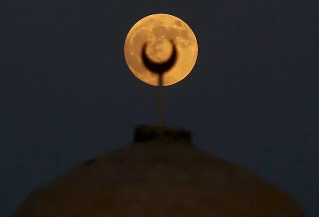A supermoon rises over a minaret of a mosque in Wadi El-Rayan Lake at the desert of Al Fayoum Governorate, south west of Cairo, Egypt, September 27, 2015. (Photo by Amr Abdallah Dalsh/Reuters)
