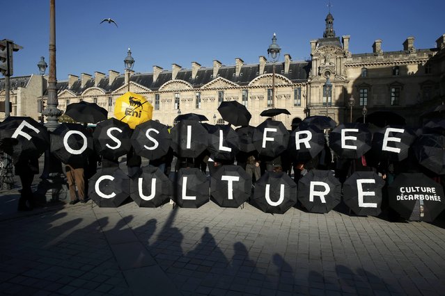 Activists stage a protest outside the Louvre pyramid, calling the museum to cancel its contracts with French oil giant Total and Italian oil company Eni, in Paris, France, December 9, 2015, as the World Climate Change Conference 2015 (COP21) continues at Le Bourget near the French capital. (Photo by Benoit Tessier/Reuters)