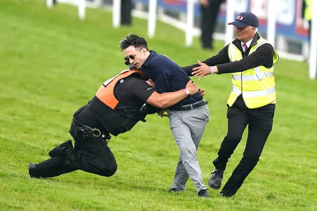 A protestor is tackled by police and stewards during the Betfred Derby during Derby Day of the 2023 Derby Festival at Epsom Downs Racecourse, Epsom, UK on Saturday, June 3, 2023. (Photo by Mike Egerton/PA Images via Getty Images)
