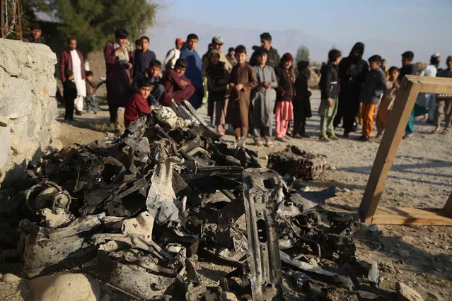 Local residents gather at the scene of a suicide car bomb blast that targeted a police post on the outskirts of Khogyani district of Nangarhar province, Afghanistan, 07 February 2021. At least one police officer was killed and two others injured in the incident. The Afghan conflict left more than 2,500 civilian casualties in the last quarter of 2020, with a significant increase in the use of explosive devices, according to the US Special Inspector General for Afghanistan Reconstruction (SIGAR). (Photo by Ghulamullah Habibi/EPA/EFE)