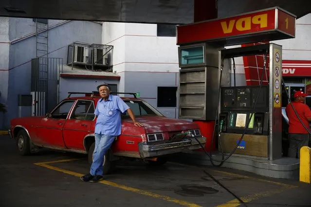 A man fills up his 1976 Chevy Nova with gasoline at a PDVSA gas station in Caracas, Venezuela, January 12, 2015. (Photo by Jorge Silva/Reuters)