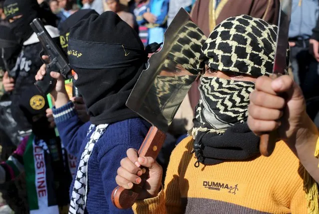A masked Palestinian boy holds a chopper during a rally organized by Islamic Jihad in Rafah in the southern Gaza Strip December 18, 2015, in support of what organizers said is a Palestinian uprising against Israel. (Photo by Ibraheem Abu Mustafat/Reuters)