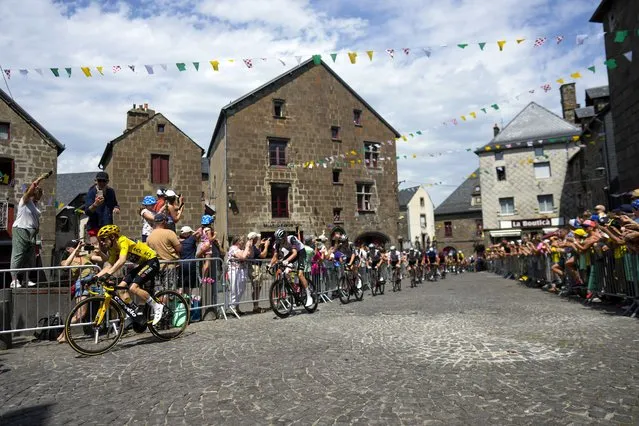 The pack with Denmark's Jonas Vingegaard, wearing the overall leader's yellow jersey, left, rides during the tenth stage of the Tour de France cycling race over 167 kilometers (104 miles) with start in Vulcania and finish in Issoire, France, Tuesday, July 11, 2023. (Photo by Thibault Camus/AP Photo)