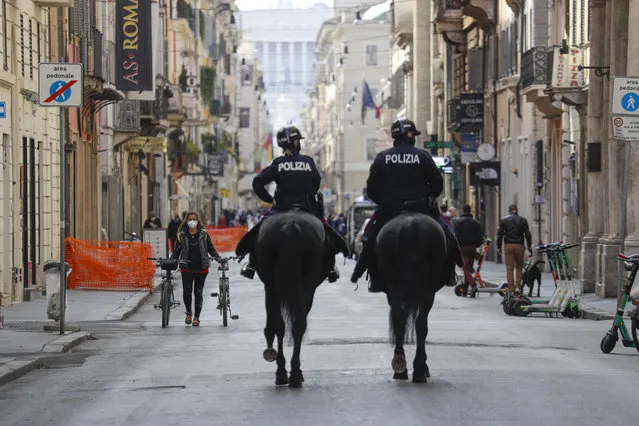 Mounted police officers patrol Via del Corso main shopping street, in downtown Rome, Saturday, April 3, 2021. Italy went into lockdown on Easter weekend in its effort to battle then Covid-19 pandemic. (Photo by Gregorio Borgia/AP Photo)