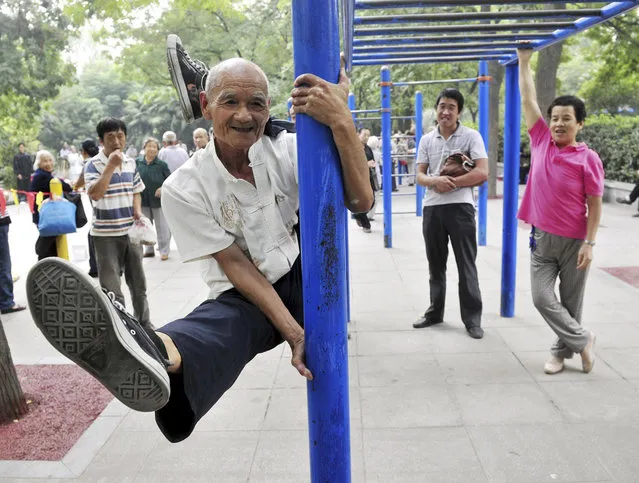 Yang Shiguang, 77, performs stunts at a park in Xi'an, Shaanxi province, September 3, 2013. Yang has been a member of a stunt performance club since 2007, after retiring from a research institution. (Photo by Reuters/China Daily)