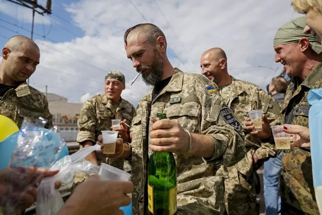 Ukrainian servicemen drink champagne after returning from the frontline in the Eastern regions, at a railway station in Kiev, Ukraine, September 9, 2015. (Photo by Gleb Garanich/Reuters)