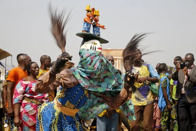 People watch a masquerade dance at the annual voodoo festival in Ouidah January 10, 2016. (Photo by Akintunde Akinleye/Reuters)
