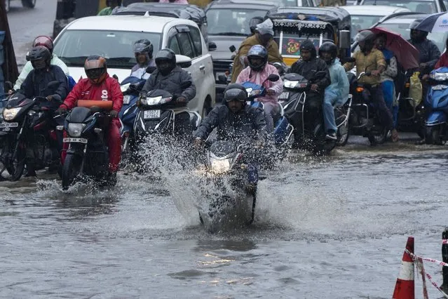 Motorists ride through a water logged street during rain in Hyderabad, India, Tuesday, September 5, 2023. The monsoon season in India lasts from June to September. (Photo by Mahesh Kumar A./AP Photo)