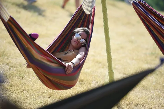 A reveller relaxes in a hammock at the Glastonbury Festival of Music and Performing Arts on Worthy Farm near the village of Pilton in Somerset, South West England, on June 21, 2017. (Photo by Oli Scarff/AFP Photo)