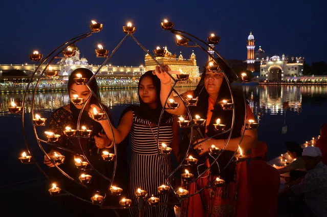 Photo taken on May 25, 2021 shows devotees lighting lamps during the birth anniversary celebration of third Sikh Guru or Master, Guru Amar Das ji at the Golden Temple in Amritsar district of north Indian state of Punjab. (Photo by Xinhua News Agency/Rex Features/Shutterstock)