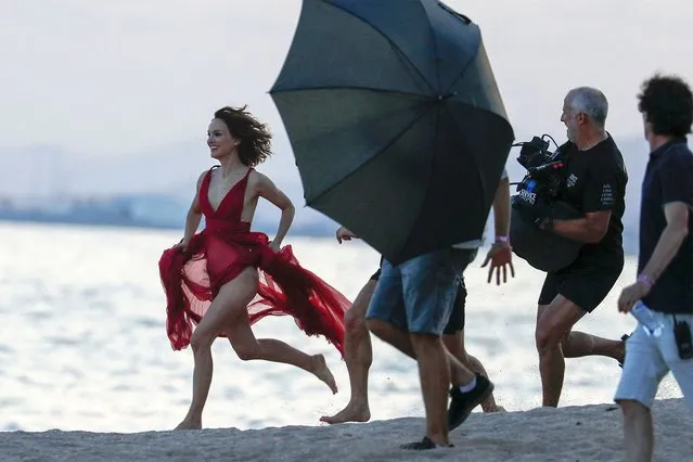 Natalie Portman looks carefree in a flowing red dress during a dreamy Dior beach shoot in Spain amid her marriage woes on September 15, 2023. The 42-year-old Oscar winning actress was throwing caution to the wind as she splashed around in the sea and ran barefoot across the sand in the sheer, plunging designer gown. Portman appeared to nail the shoot as she threw herself into her work despite facing major problems in her 11-year marriage to Benjamin Millipied, due to cheating claims. She and the French producer and choreographer have been spotted out without their wedding rings as they continue to co-parent their two children. (Photo by Emilio Utrabo/The Mega Agency)