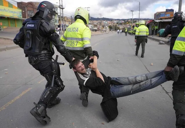 Police detain a man during continuing anti-government protests triggered by proposed tax increases on public services, fuel, wages and pensions in Bogota, Colombia, Monday, June 28, 2021. (Photo by Fernando Vergara/AP Photo)