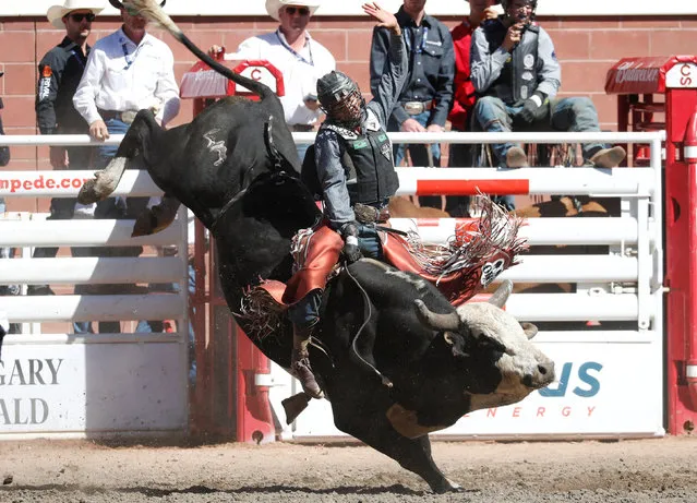 Reid Oftedahl of Raymond, Minnesota rides the bull Blitz Kraig in the bull riding event during the Calgary Stampede rodeo in Calgary, Alberta, Canada on July 11, 2022. (Photo by Todd Korol/Reuters)