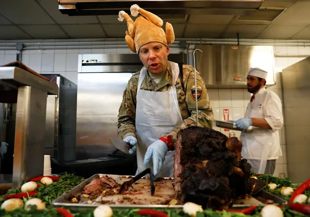 A U.S. Army soldier serves Thanksgiving meal to his comrades at the Resolute Support headquarters in Kabul, Afghanistan on November 22, 2018. (Photo by Mohammad Ismail/Reuters)