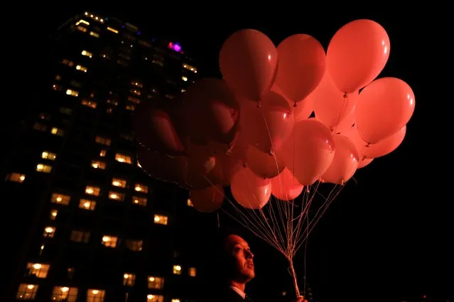 A Japanese man holds balloons during the New Year celebrations at Prince Park Tower in Tokyo on December 31, 2016. (Photo by Behrouz Mehri/AFP Photo)