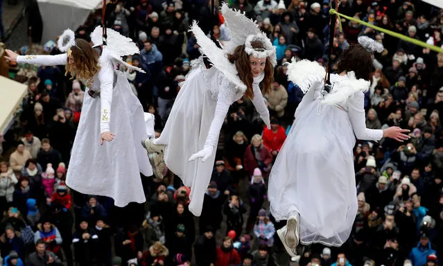 Women dressed as angels wave to spectators as they hang from a wire during a Christmas market in the town of Ustek, Czech Republic December 15, 2018. (Photo by David W. Cerny/Reuters)