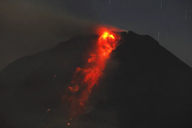 A long exposure photo shows star trails as Mount Sinabung volcano spews hot lava as seen from Jraya village in Karo district, January 9, 2014. (Photo by Y. T. Haryono/Reuters)