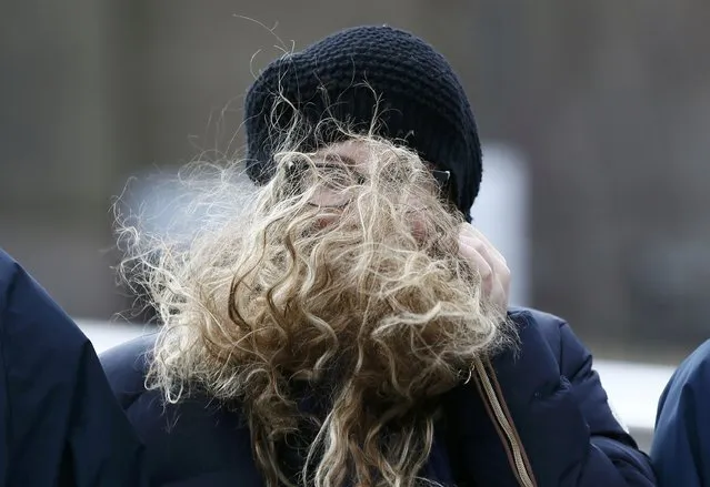 A woman' s hair is blown across her face as she crosses the Millennium Bridge during strong winds in London, Britain February 8, 2016. (Photo by Stefan Wermuth/Reuters)