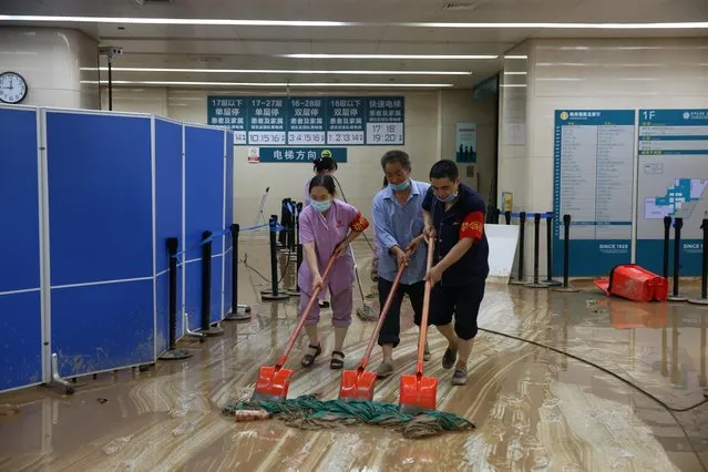 Workers carry out cleaning work at the First Affiliated Hospital of Zhengzhou University, which faces water and power shortage due to heavy rainfall in Zhengzhou, Henan province, China on July 21, 2021. (Photo by China Daily via Reuters)