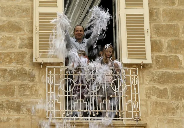 People in a balcony throw confetti over a statue of the Risen Christ during an Easter Sunday procession in Cospicua, outside Valletta April 5, 2015. (Photo by Darrin Zammit Lupi/Reuters)