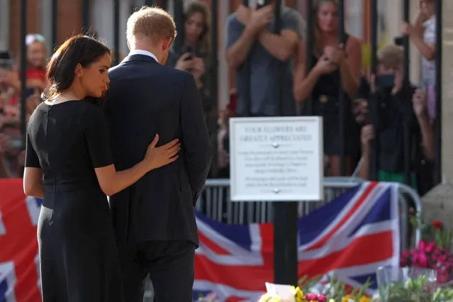 Prince Harry and Meghan, the Duchess of Sussex, look at floral tributes as they walk outside Windsor Castle in Windsor, Britain on September 10, 2022. (Photo by Paul Childs/Reuters)