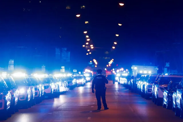 A Chicago police officer stands on the street following the procession with the bodies as two fallen Chicago police officers arrive at the medical examiner's office in Chicago, Tuesday morning, December 18, 2018. Chicago police say two officers investigating a shots-fired call on the city’s far South Side have died after being struck by a train.. (Photo by Jose M. Osorio/Chicago Tribune via AP Photo)