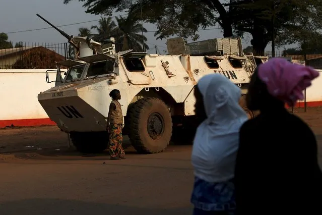 Women walk by a United Nations peacekeeping armoured vehicle guarding the outer perimeter of a compound of a school used as an electoral centre at the end of the presidential and legislative elections, in the mostly muslim PK5 neighbourhood of Bangui, Central African Republic, February 14, 2016. (Photo by Siegfried Modola/Reuters)