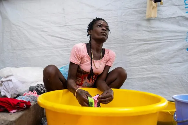 A woman washes clothes at a shelter for families displaced by gang violence at the Saint Yves Church in Port-au-Prince, Haiti on July 26, 2021. (Photo by Ricardo Arduengo/Reuters)