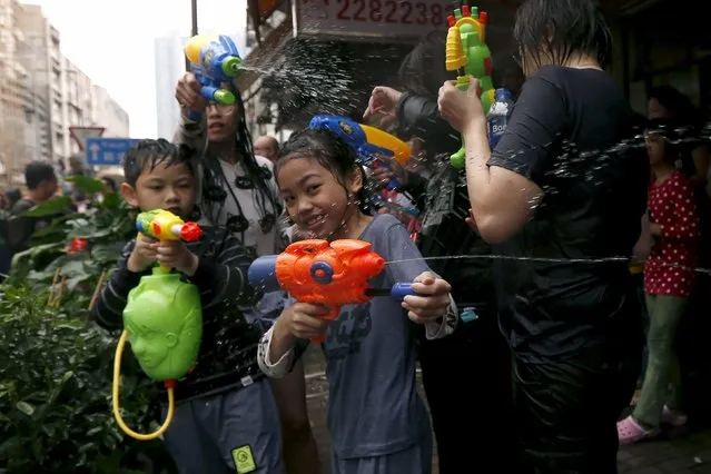 Children use water guns as they participate in a water fight during Songkran Festival celebrations at Kowloon City district, known as Little Thailand as there is large number of restaurants and shops run by Thais, April 12, 2015. (Photo by Tyrone Siu/Reuters)