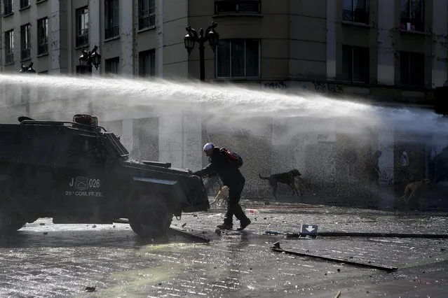 A protester blocks the way to a riot police vehicle during a demonstration against the government to demand changes in the education system at Santiago, April 16, 2015. (Photo by Ivan Alvarado/Reuters)