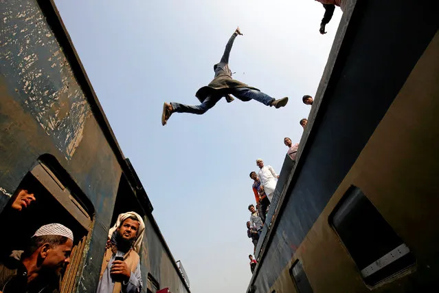 A commuter jumps between trains upon arrival at a station, to attend Akheri Munajat, the final supplication during Biswa Ijtema in Tongi, on the outskirts of Dhaka January 15, 2017. (Photo by Mohammad Ponir Hossain/Reuters)