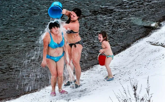 Members of the “Krepysh” family winter swimming club pour icy water onto each other on the banks of the Yenisei River, despite the 23 degree temperature in Russia's Siberian city of Krasnoyarsk, December 29, 2013. (Photo by Ilya Naymushin/Reuters)