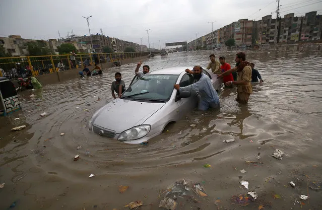 People make their way during heavy rains in Karachi, Pakistan, 23 September 2021. Most of the Pakistani cities are experiencing prolonged ​monsoon season this year. (Photo by Shahzaib Akber/EPA/EFE)