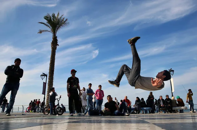 Syrian refugee Mohammed al-Shareef, 20, who fled with his family from Damascus, Syria, performs a breakdance on the Mediterranean waterfront promenade in Beirut, Lebanon, Sunday, March 6, 2016. (Photo by Bilal Hussein/AP Photo)