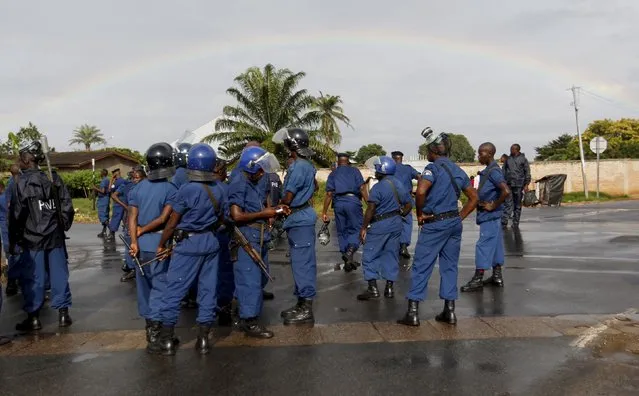 A rainbow is seen in the sky as riot policemen take a break during street protests against the decision made by Burundi's ruling National Council for the Defence of Democracy-Forces for the Defence of Democracy (CNDD-FDD) party to allow President Pierre Nkurunziza to run for a third five-year term in office, in the capital Bujumbura, April 26, 2015. (Photo by Thomas Mukoya/Reuters)