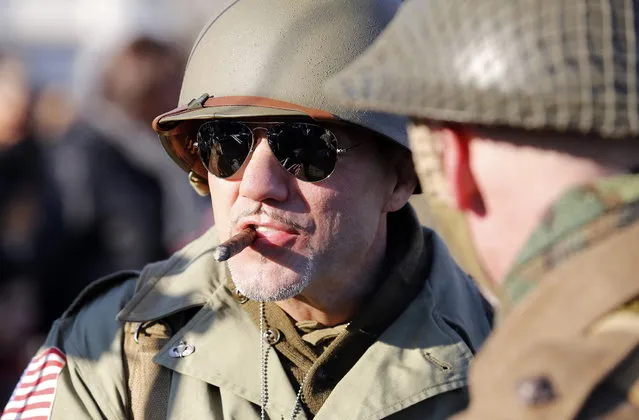 A volunteer wearing the uniform of the U.S. army smokes a cigar as he participates in the re-enactment of a World War Two landing to mark its 70th anniversary in Anzio, near Rome, January 25, 2014. (Photo by Stefano Rellandini/Reuters)