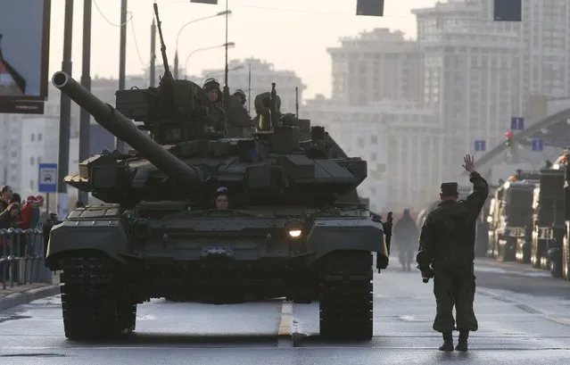 Russian servicemen are seen onboard a T-90 tank in a street before a rehearsal for the Victory Day parade in Moscow, Russia, April 29, 2015. (Photo by Maxim Zmeyev/Reuters)