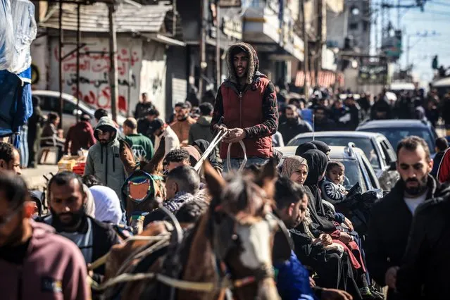 People who fled fighting in the Gaza Strip gather along an overcrowded street in Rafah in the southern part of the Palestinian territory on February 1, 2024, as battles between Israel and the militant group Hamas continue. (Photo by Mahmud Hams/AFP Photo)