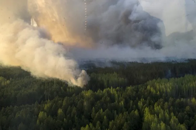 An aerial view through a window of a helicopter shows smoke from forest fires in northern Ukraine, April 28, 2015. Emergency services were battling on Tuesday to prevent Ukraine's largest forest fire since 1992 from spreading towards the abandoned Chernobyl nuclear power plant, Prime Minister Arseny Yatseniuk said. Earlier, the interior ministry had warned that high winds were blowing the fire in northern Ukraine towards Chernobyl, where in 1986 a reactor fire led to the world's worst nuclear disaster. (Photo by Andrew Kravchenko/Reuters)