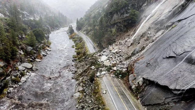Rocks and vegetation cover Highway 70 following a landslide in the Dixie Fire zone on Sunday, October 24, 2021, in Plumas County, Calif. Heavy rains blanketing Northern California created slide and flood hazards in land scorched during last summer's wildfires. (Photo by Noah Berger/AP Photo)